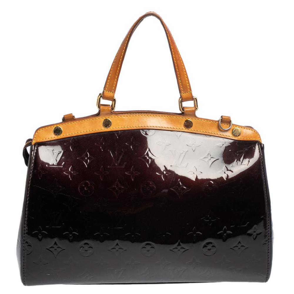 The feminine shape of Louis Vuitton's Brea is inspired by the doctor's bag. Crafted from Monogram vernis, the bag has a perfect finish. The fabric interior is spacious and it is secured by a zipper. The bag features double handles, protective metal