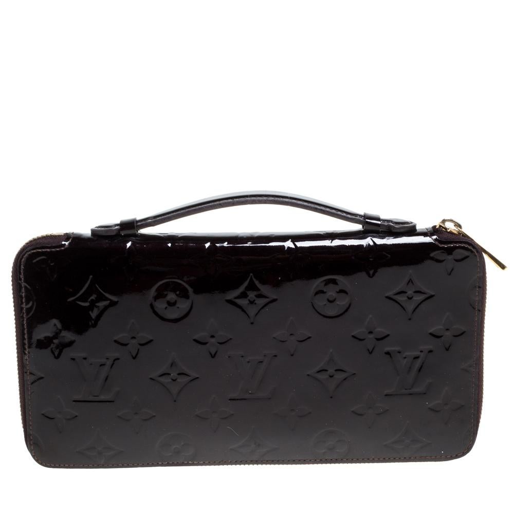 Add ease and style when traveling with this travel organizer designed by Louis Vuitton. The Monogram Vernis organizer is secured by zippers and is designed to keep your essentials more organized. It has multiple slots as well as compartments, a top