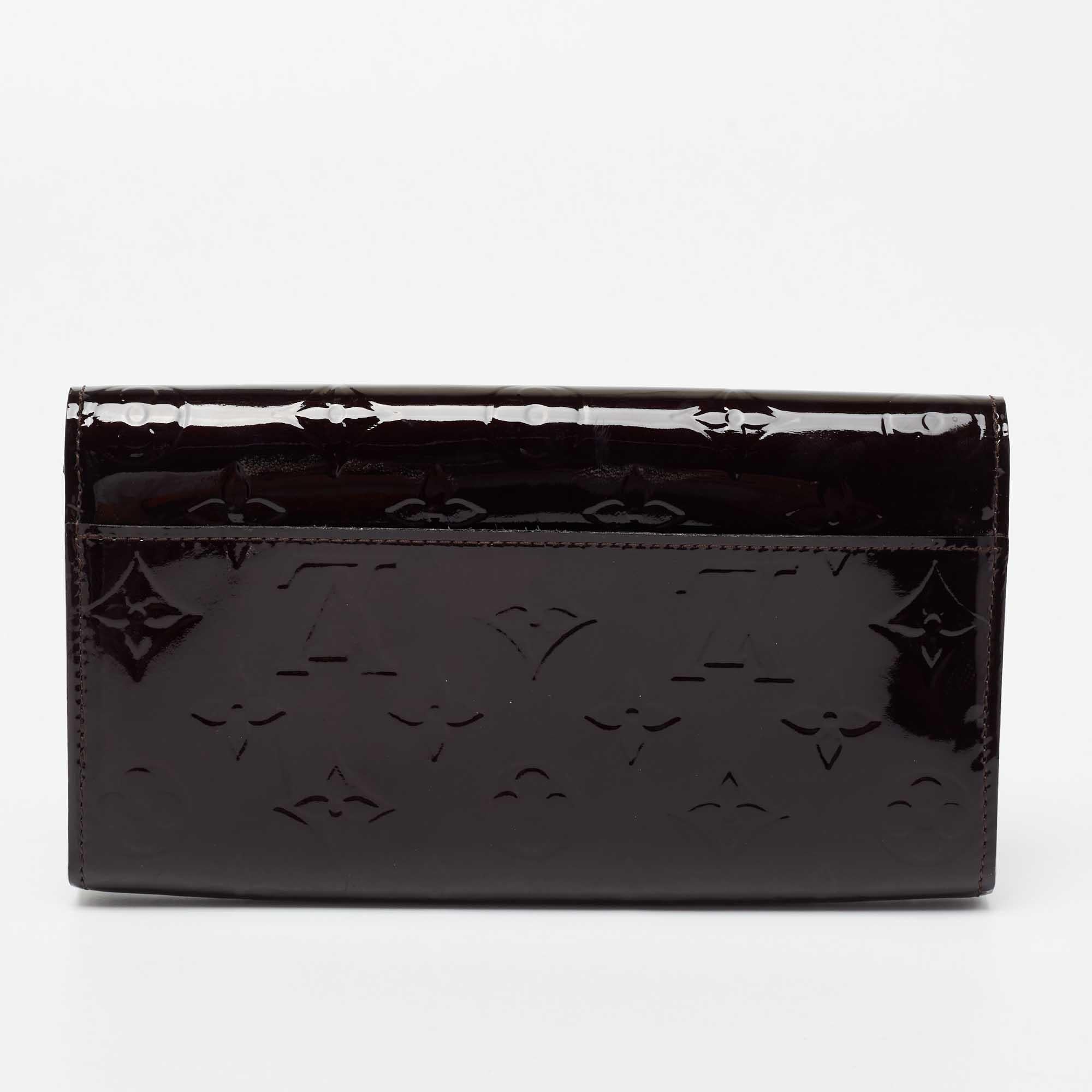 Made using Monogram Vernis, this wallet from Louis Vuitton has a simple look and functional quality. The flap opens to a sleek interior featuring a zip pocket and card slots.

