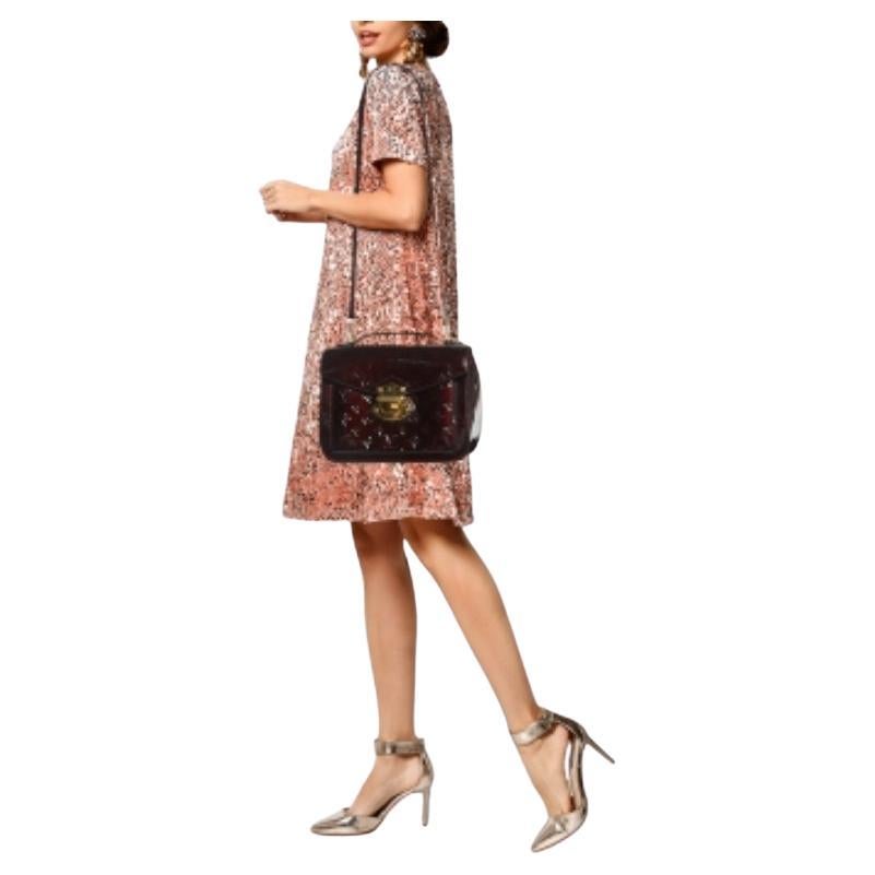 Este bolso Louis Vuitton Mirada tiene un diseño compacto con asa superior y cierre metálico en la solapa. Esta creación en Monogram Vernis presenta un interior forrado de tela, herrajes dorados y una bandolera desmontable.
