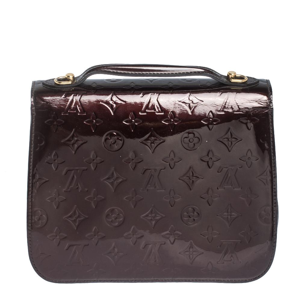 This Louis Vuitton Mirada bag carries oodles of style and sophistication. Crafted in France, it is made of glossy Monogram Vernis leather. It comes in a lovely shade of burgundy. It has a flap top with a gold-tone push-lock closure that accentuates