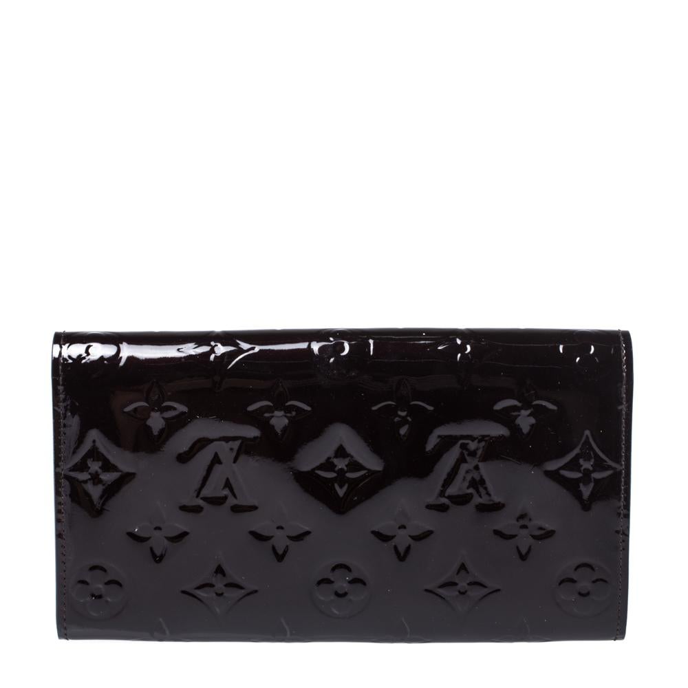 One of the most famous wallets by Louis Vuitton is the Sarah. This one here comes made from Monogram Vernis leather and the button on the flap opens to an interior with multiple card slots and a zip pocket. Perfect in size, this wallet can easily