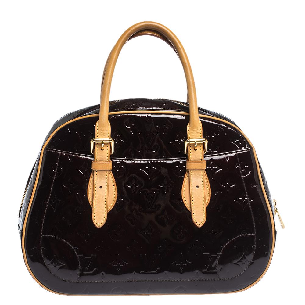 Elegant and polished, this bag takes you through your day with ease. Crafted in a smart silhouette from monogram Vernis, it comes in a stunning shade. The bag features dual-rolled handles and exterior slip pockets. The bag is secured by a wide