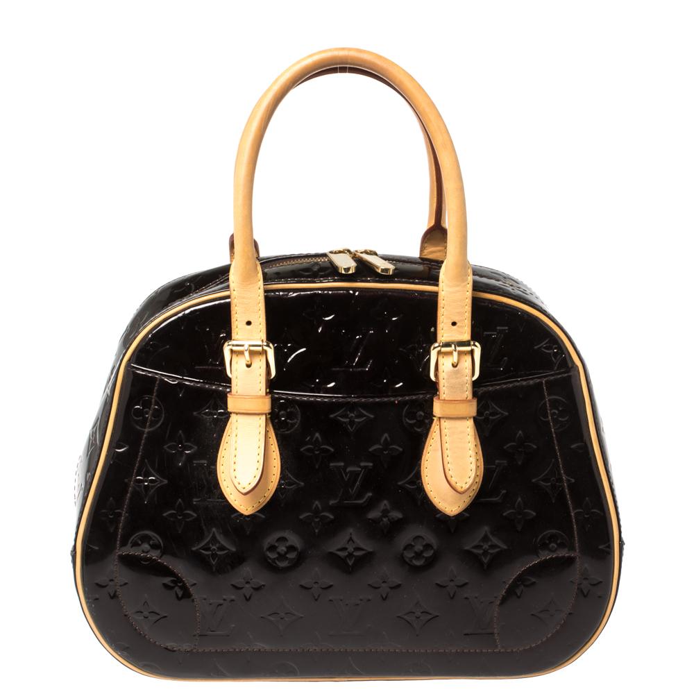 Elegant and chic, this Louis Vuitton bag takes you through your day with ease. Crafted from Amarante Monogram Vernis patent leather featuring dual-rolled handles and exterior slip pockets, it is secured by a wide two-way zip closure that opens to a