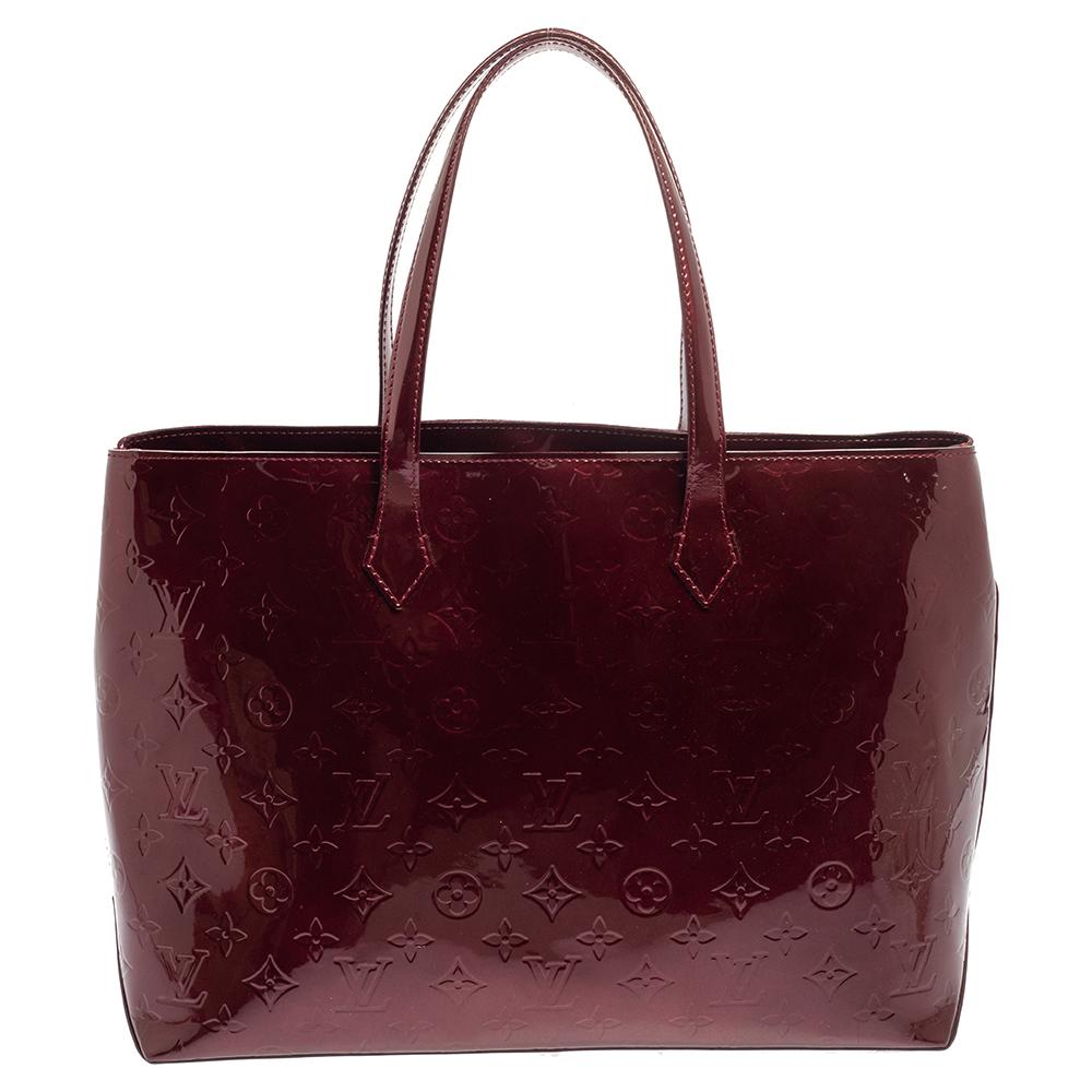 Louis Vuitton's handbags are popular owing to their high style and functionality. This Wilshire bag, like all the other handbags, is durable and stylish. Crafted from Monogram Vernis, the Amarante bag comes with dual handles and a top with a hook to