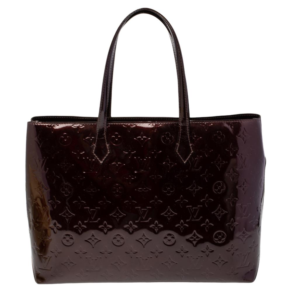 Louis Vuitton's handbags are popular owing to their high style and functionality. This Wilshire bag, like all the other handbags, is durable and stylish. Crafted from Monogram Vernis leather, the burgundy bag comes with dual handles and a top with a