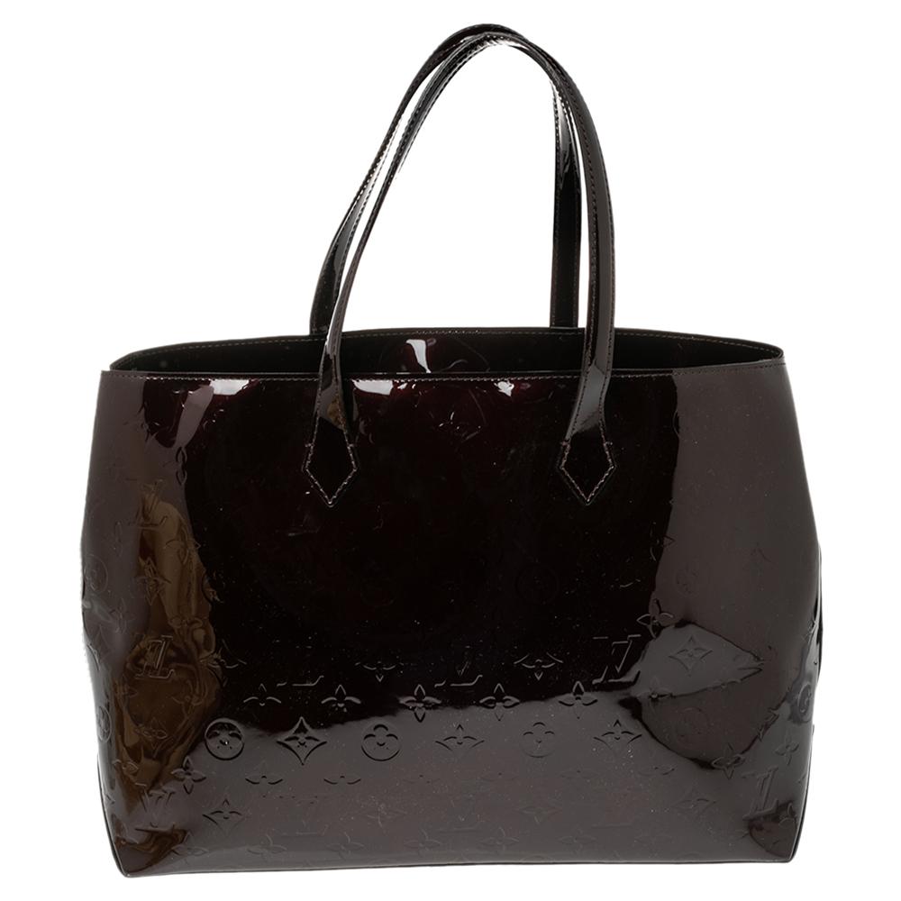 Louis Vuitton's handbags are popular owing to their high style and functionality. This Wilshire bag, like all the other handbags, is durable and stylish. Crafted from Monogram Vernis leather, the burgundy bag comes with dual handles and a top with a