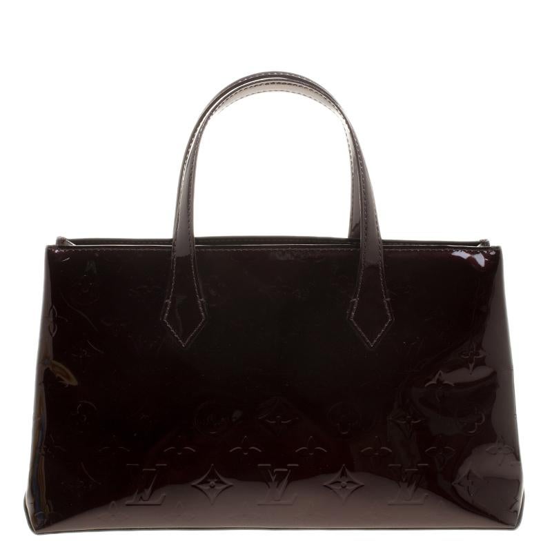 Louis Vuitton's handbags are popular owing to their high style and functionality. This Wilshire bag, like all the other handbags, is durable and stylish. Crafted from Amarante Monogram Vernis, the burgundy bag comes with dual handles and a top with