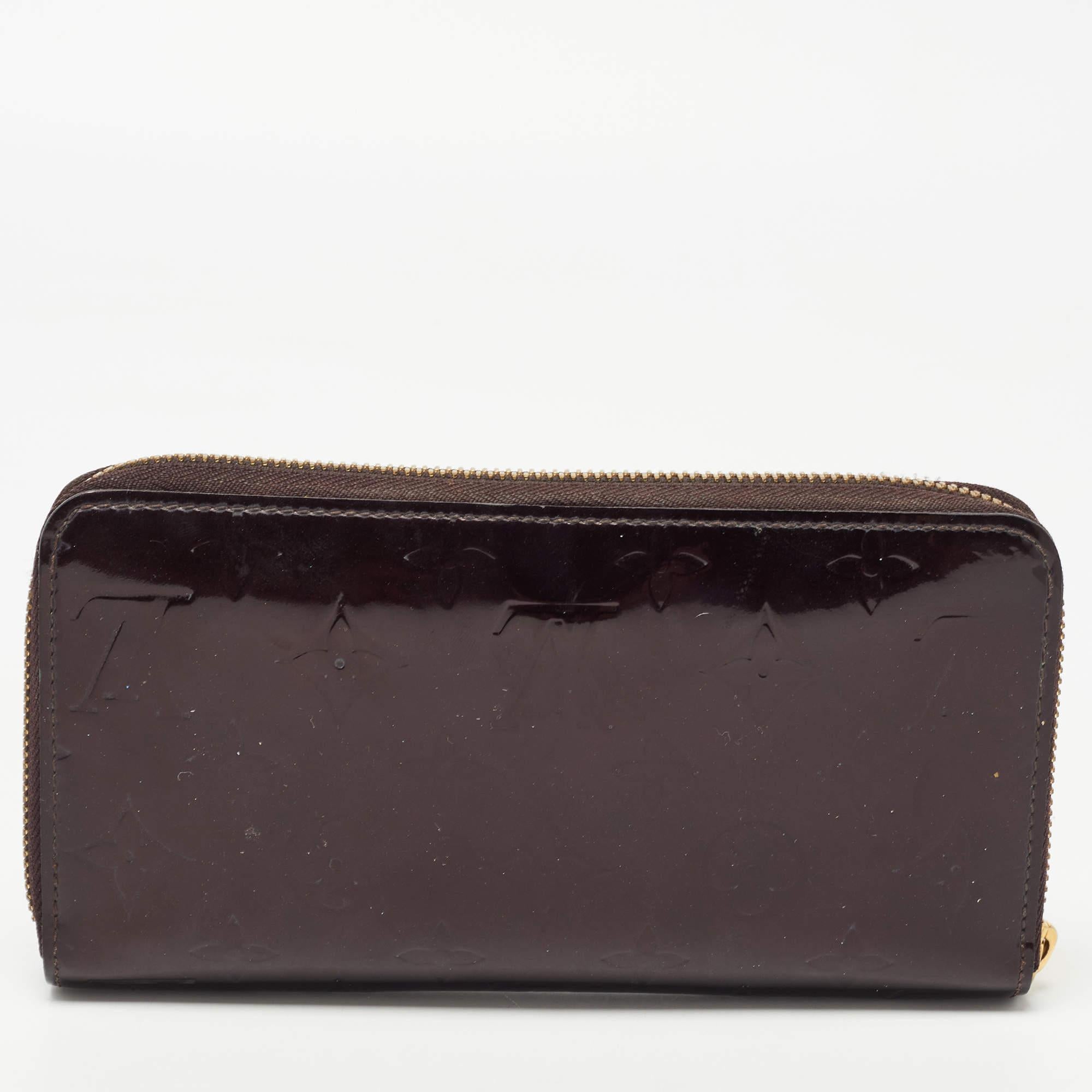 This Louis Vuitton Zippy wallet is conveniently designed for everyday use. Crafted from Amarante Monogram Vernis , it is paired with a zip-around closure and gold-tone hardware. The compartmentalized interior of the wallet will store your card and