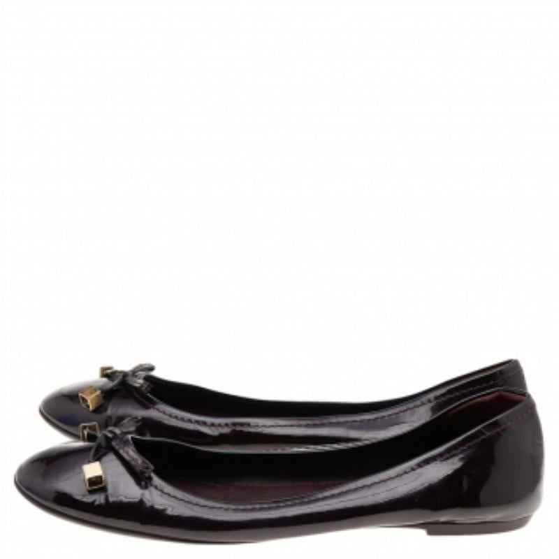 Queste ballerine di Louis Vuitton sono semplici e sofisticate. Sono realizzate in pelle verniciata, decorate con fiocchi dorati sulla tomaia e dotate di comode solette. Abbinali a gonne e vestiti.