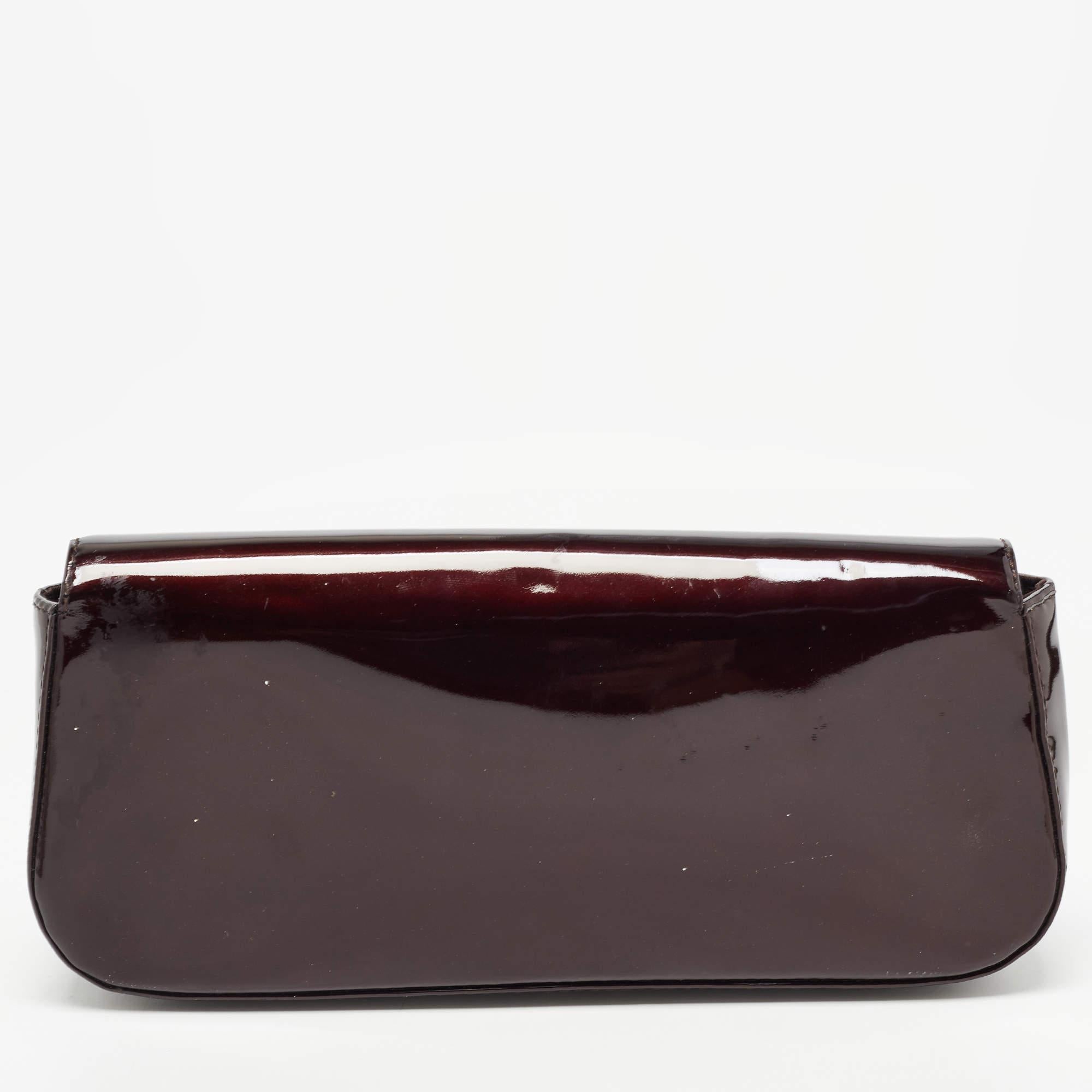 Well-crafted and overflowing with style, this Sobe clutch is from Louis Vuitton. It has a patent leather exterior, a fabric interior, and a large LV adorned on the flap. This creation will lift all your gowns and elegant outfits.

Includes: Original