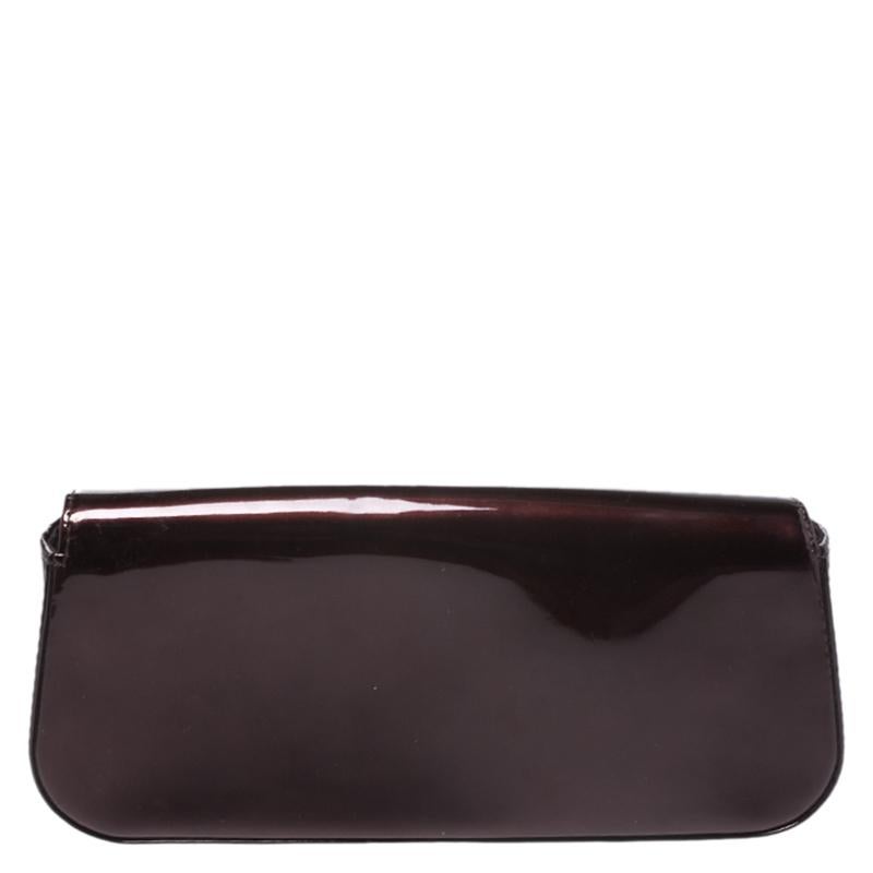 This exquisite Sobe clutch from Louis Vuitton is a must-have and will make sure you are the talk of the town. It comes in the brand's signature Vernis finish and has a simple design. The burgundy color adds interest. The brand's logo is beautifully