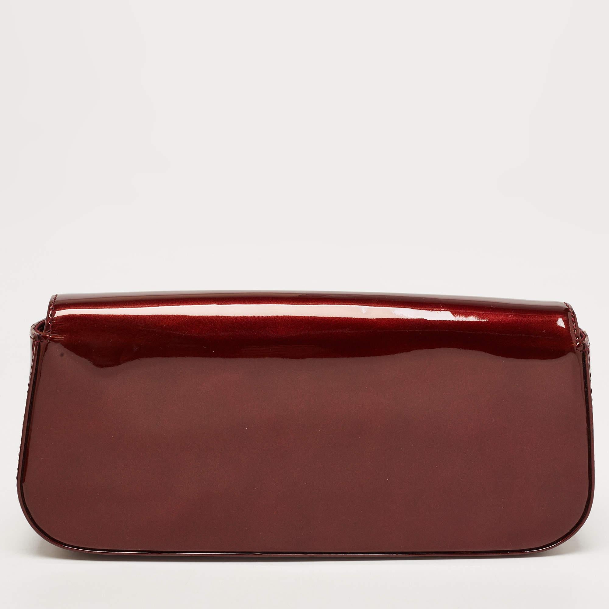This exquisite Sobe clutch from Louis Vuitton comes in the brand's signature Vernis finish and has a simple design. The brand's logo is beautifully displayed on the flap which opens to a fabric-lined interior that can house all your evening