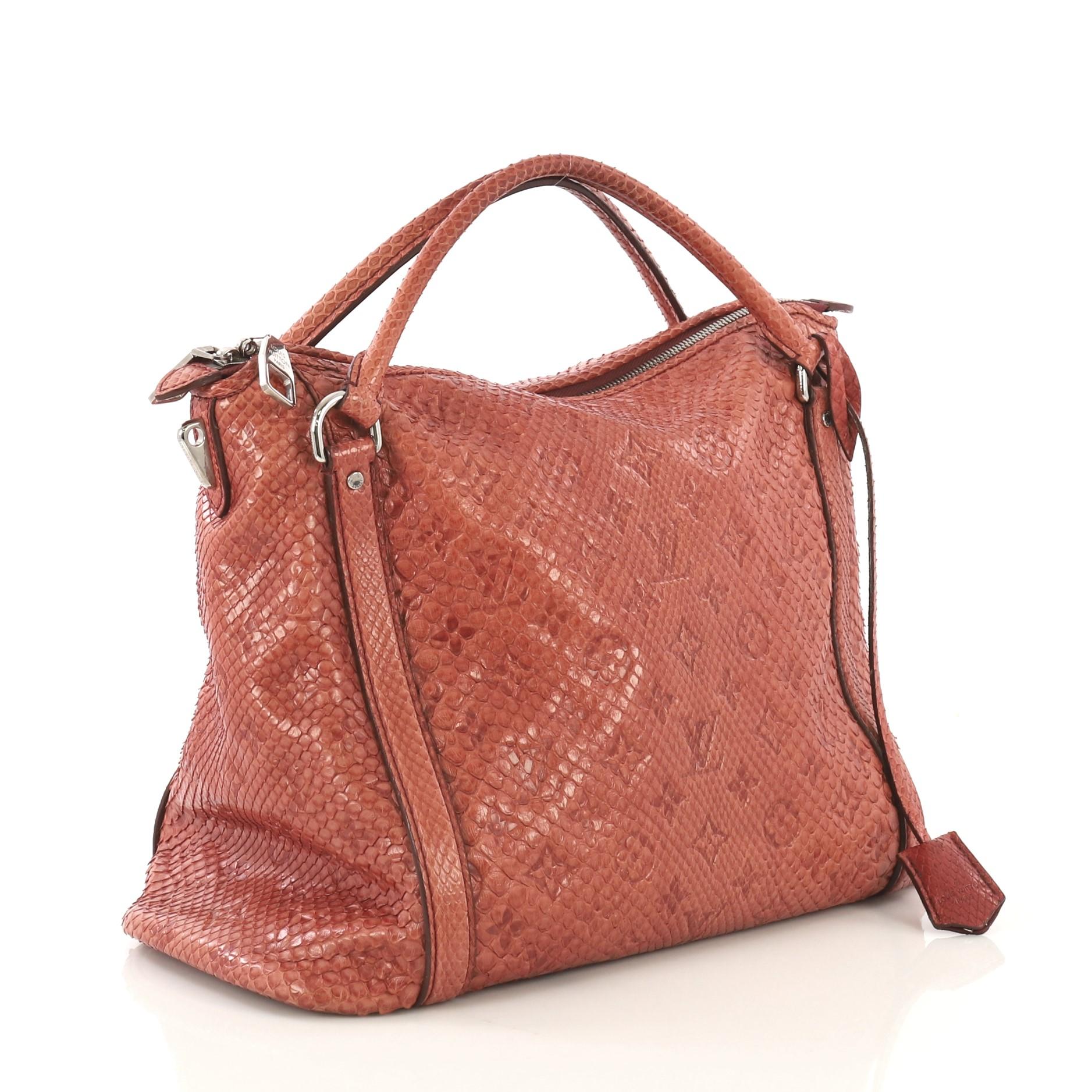 This Louis Vuitton Antheia Ixia Handbag Python PM, crafted in genuine pink python, features dual rolled leather handles, monogram flower patterns, and silver-tone hardware. Its zip closure opens to a red leather interior with zip and slip pockets.