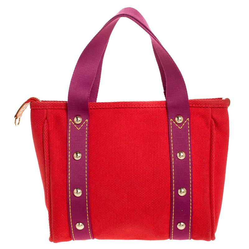 This Antigua Cabas PM tote by Louis Vuitton is a tote you’ll love to bring everywhere. Crafted from durable pink canvas, it is accented with contrastingly-colored trims with gold studs and a large Louis Vuitton logo plaque. Its interior is lined
