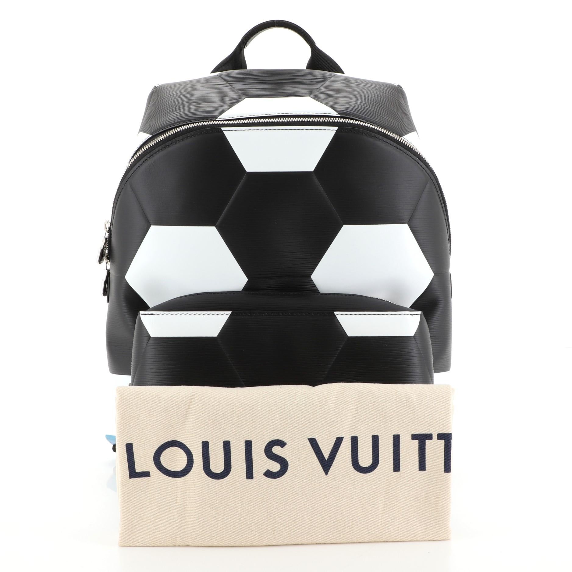 This Louis Vuitton Apollo Backpack Limited Edition FIFA World Cup Epi Leather, crafted from white, black and printed epi leather, features a top handle, adjustable back straps, hexagonal pattern of footballs, exterior front zip pocket, and