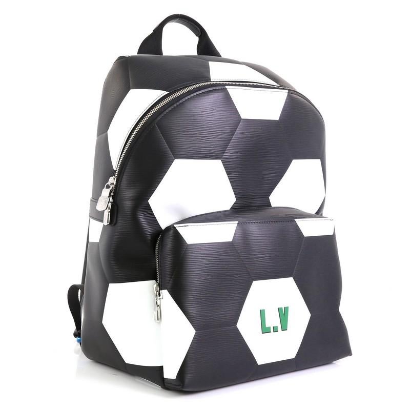 This Louis Vuitton Apollo Backpack Limited Edition FIFA World Cup Epi Leather, crafted from white and black epi leather, features a top handle, adjustable back straps, hexagonal pattern of footballs, exterior front zip pocket, and silver-tone