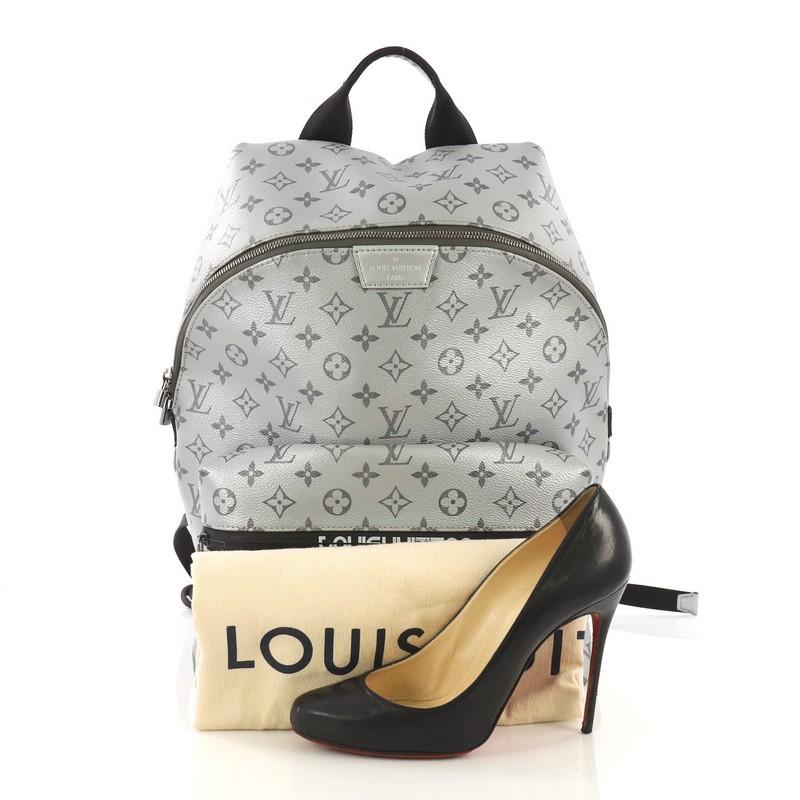 This Louis Vuitton Apollo Backpack Limited Edition Reflect Monogram Canvas, crafted from silver reflect monogram canvas, features a top handle, adjustable back straps, exterior front zip compartment, and gunmetal-tone hardware. Its two-way zip