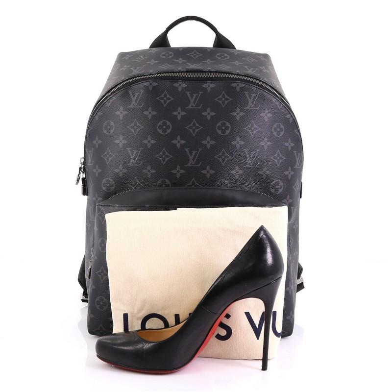 This Louis Vuitton Apollo Backpack Monogram Eclipse Canvas, crafted from black monogram eclipse coated canvas, features a top handle, adjustable back straps, exterior front zip compartment, and gunmetal-tone hardware. Its two-way zip closure opens