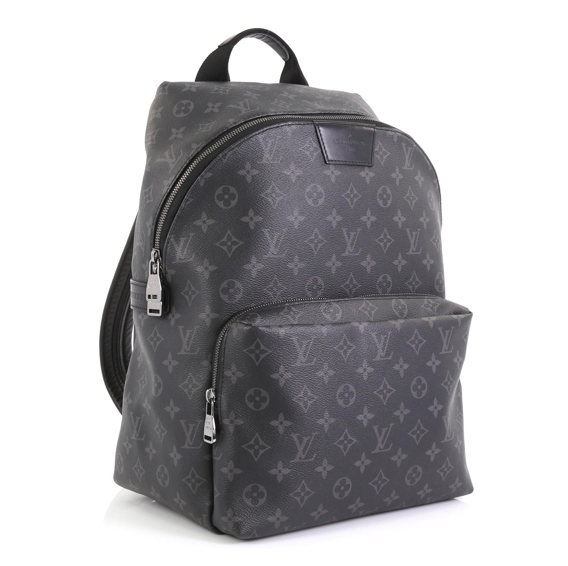 This Louis Vuitton Apollo Backpack Monogram Eclipse Canvas, crafted from monogram eclipse coated canvas, features a top handle, adjustable back straps, exterior front zip compartment, and gunmetal-tone hardware. Its two-way zip closure opens to a