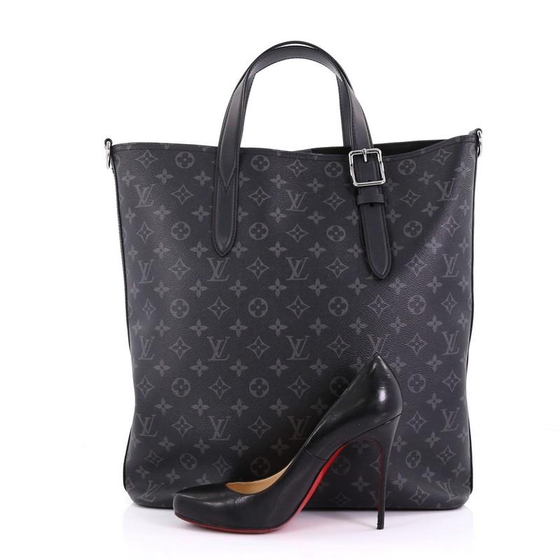 This Louis Vuitton Apollo Tote Monogram Eclipse Canvas, crafted from black monogram eclipse coated canvas, features dual leather handles and silver-tone hardware. Its magnetic snap button closure opens to a black fabric interior with zip and slip