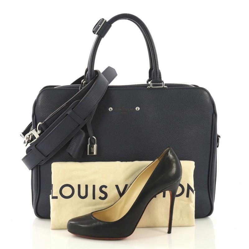This Louis Vuitton Armand Briefcase Taurillon Leather, crafted from navy blue taurillon leather, features dual rolled leather handles and silver-tone hardware. Its zip closure opens to an orange microfiber interior with zip and slip pockets.