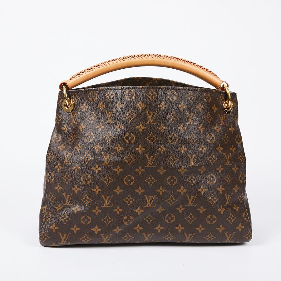 The Louis Vuitton Artsy bag is made of Monogram coated canvas. Its handle is smooth woven cow leather. The jewelery is in golden brass. The bag has its zipper with key ring and hook. It is lined in beige suede and has the large zipped pocket and six