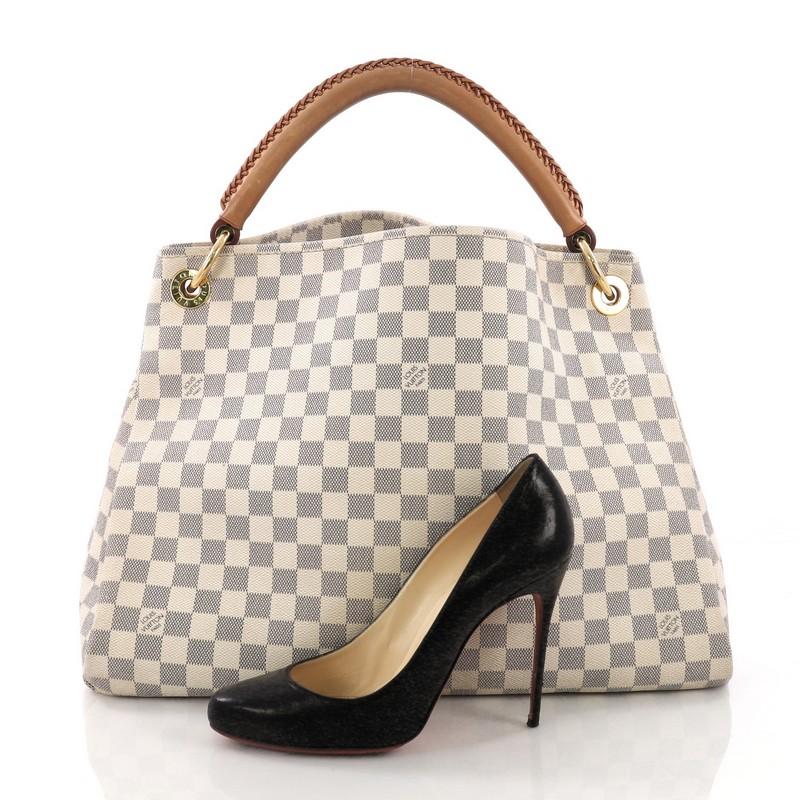 This Louis Vuitton Artsy Handbag Damier MM, crafted from damier azur coated canvas, features a single looped hand-crafted leather handle, protective base studs, and gold-tone hardware. Its wide open top showcases a beige microfiber interior with zip