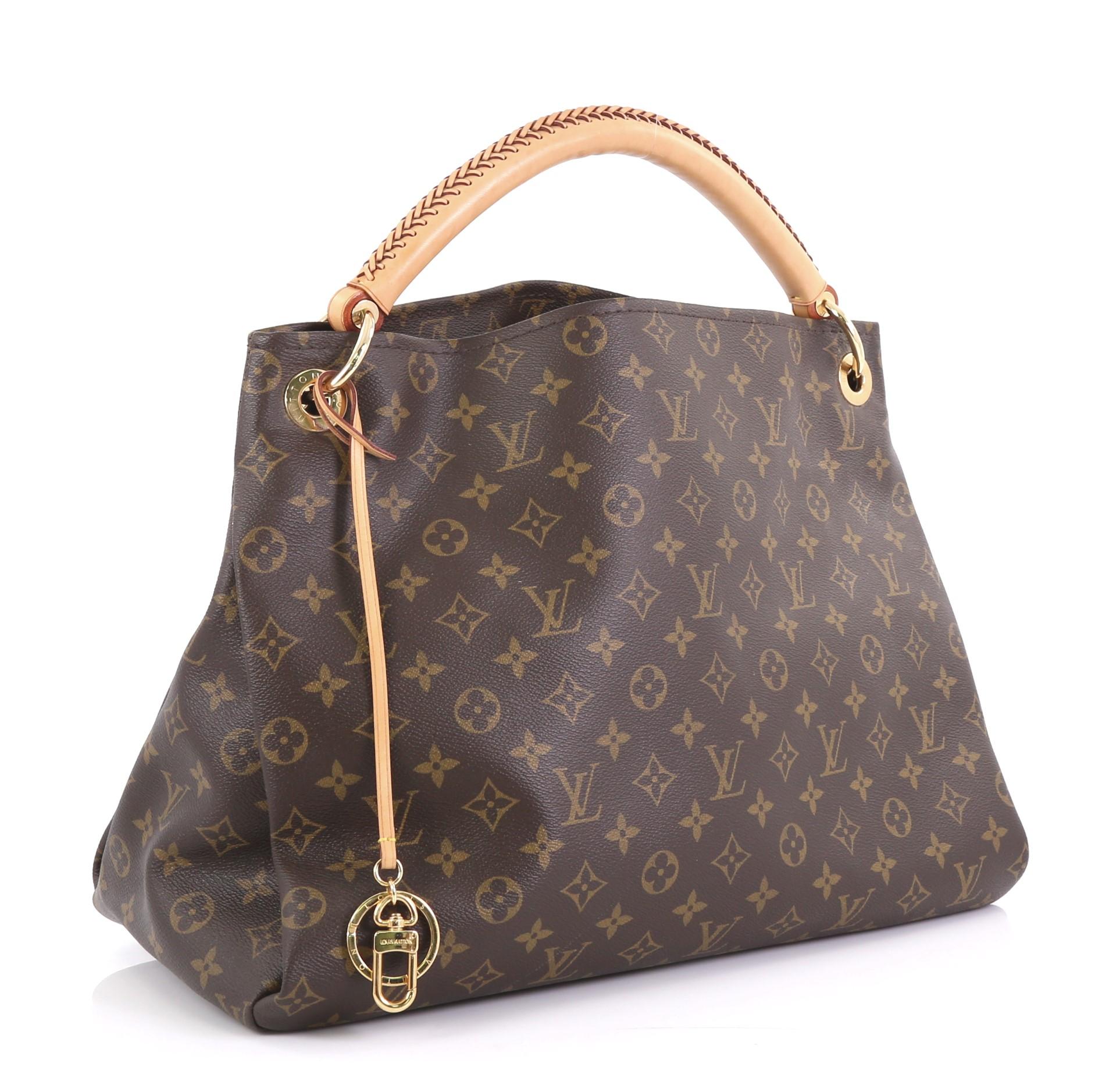 This Louis Vuitton Artsy Handbag Monogram Canvas MM, crafted from brown monogram coated canvas, features a rolled leather handle with braided detailing, protective base studs, and gold-tone hardware. It opens to a beige microfiber interior with side