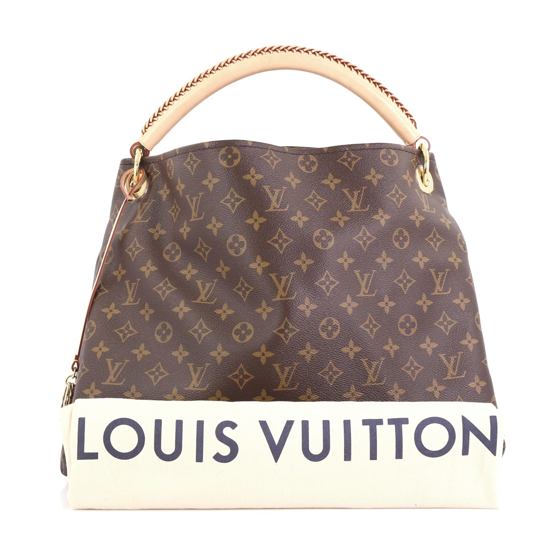 This Louis Vuitton Artsy Handbag Monogram Canvas MM, crafted from brown monogram coated canvas, features a rolled leather handle with braided detailing, protective base studs, and gold-tone hardware. It opens to a beige canvas interior with side zip