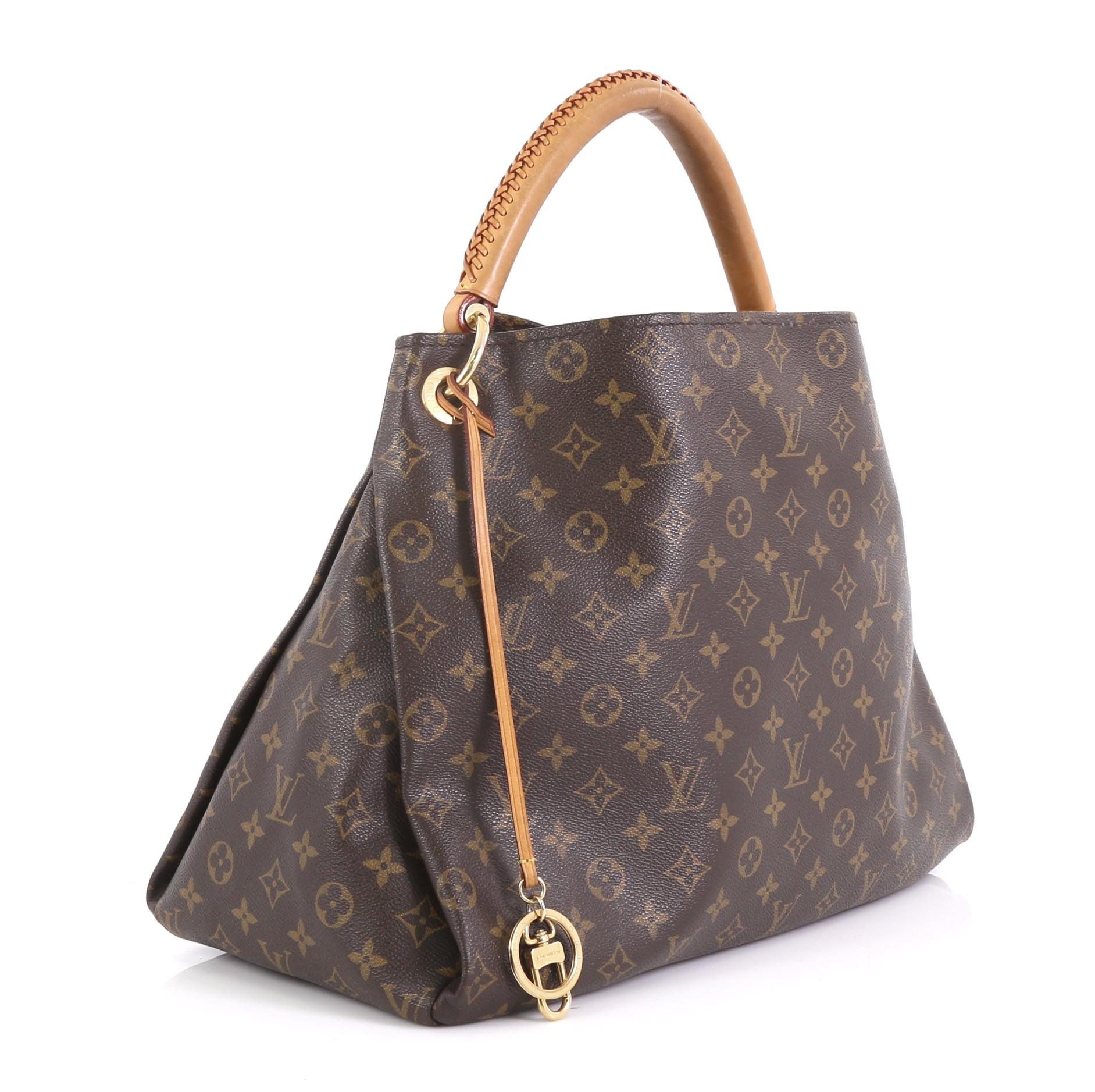 This Louis Vuitton Artsy Handbag Monogram Canvas MM, crafted from brown monogram coated canvas, features rolled leather handle with braided detailing, protective base studs, and gold-tone hardware. It opens to a beige microfiber interior with side