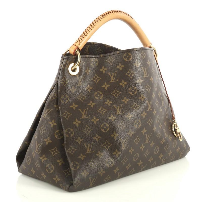 This Louis Vuitton Artsy Handbag Monogram Canvas MM, crafted from brown monogram coated canvas, features a rolled leather handle with braided detailing, protective base studs, and gold-tone hardware. It opens to a neutral microfiber interior with