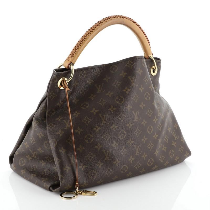 This Louis Vuitton Artsy Handbag Monogram Canvas MM, crafted from brown monogram coated canvas, features a rolled leather handle with braided detailing, protective base studs, and gold-tone hardware. It opens to a neutral microfiber interior with