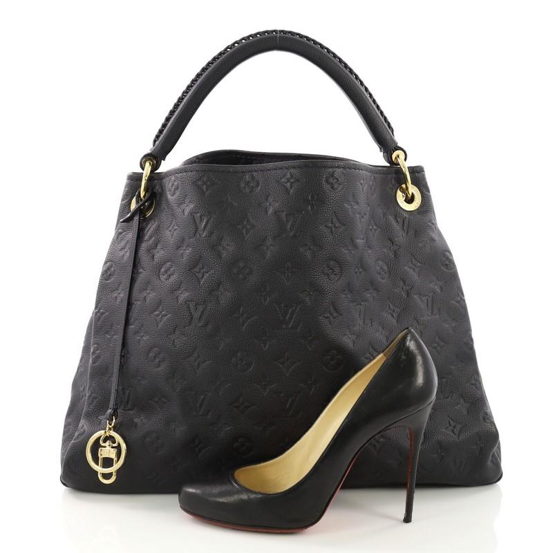 This Louis Vuitton Artsy Handbag Monogram Empreinte Leather MM, crafted from navy monogram embossed empreinte leather, features a single looped braided top handle, protective base studs and gold-tone hardware. Its wide open top showcases a blue