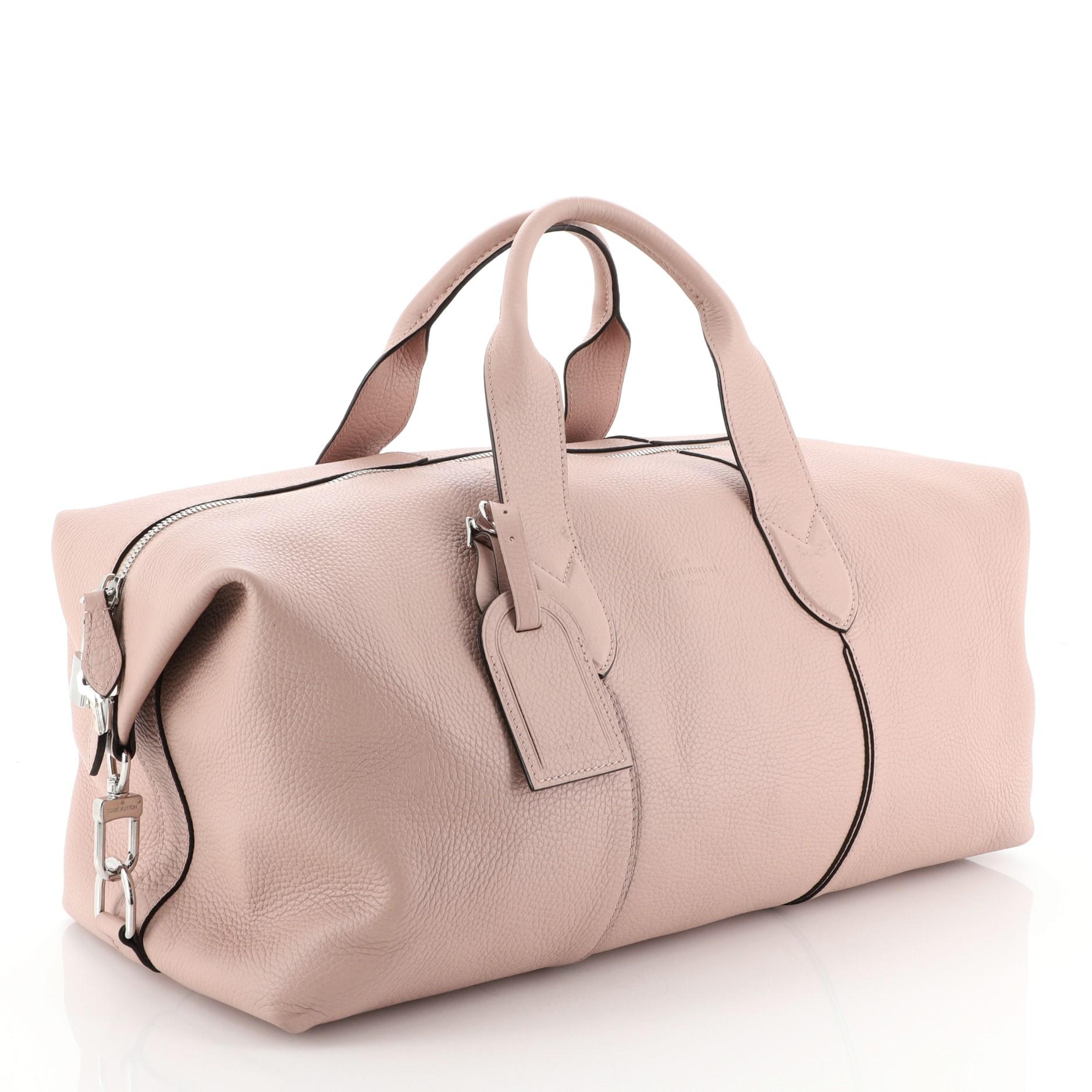 This Louis Vuitton Astralis Bag Leather 50, crafted from pink leather, features dual rolled leather handles and silver-tone hardware. Its two-way zip closure opens to a brown microfiber interior with zip and slip pockets. Authenticity code reads: