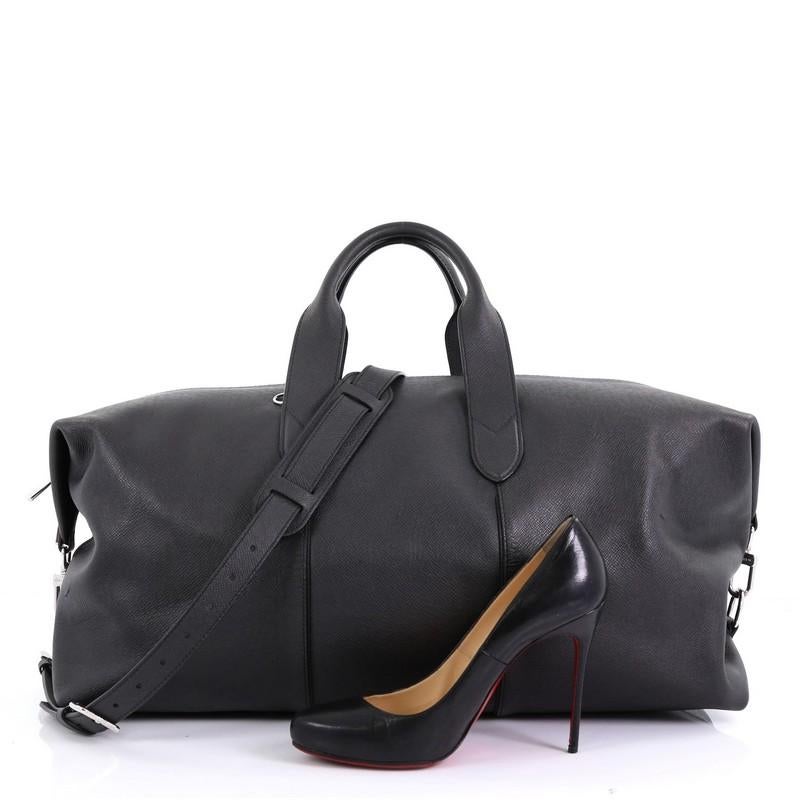 This Louis Vuitton Astralis Bag Taiga Leather 50, crafted from black taiga leather, features dual rolled top handles and silver-tone hardware. Its zip closure opens to a black fabric interior with zip and slip pockets. Authenticity code reads: