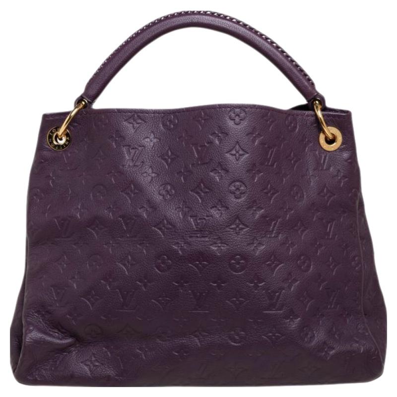 Flaunt this Louis Vuitton Artsy bag like a fashionista! Crafted from their signature Monogram Empreinte leather, this bag features an open top that reveals a canvas-lined interior, spacious enough to carry all your essentials. The purple bag is