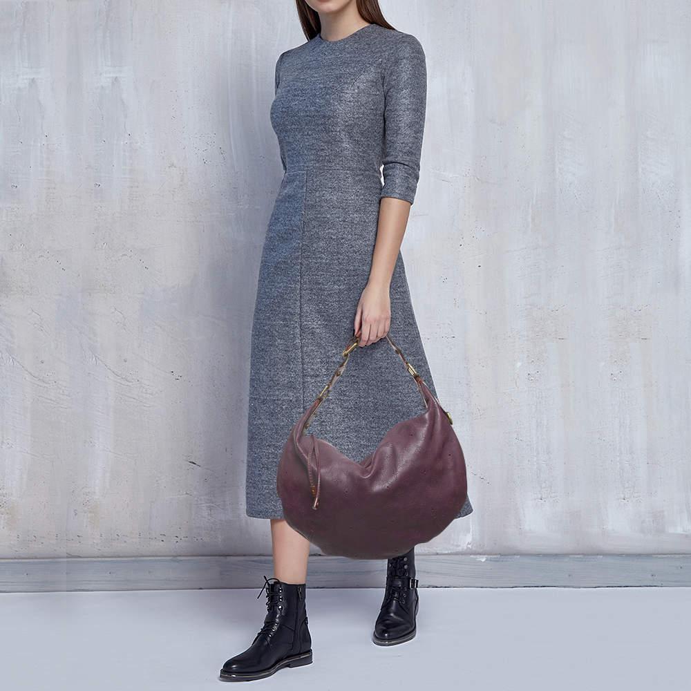 Chic and vibrant this Louis Vuitton bag is adored for its feminine pattern and color. Crafted from monogrammed leather with gold tone hardware it features one top handle with buckle and a zip closure with a dangling pull. Its fabric interior houses