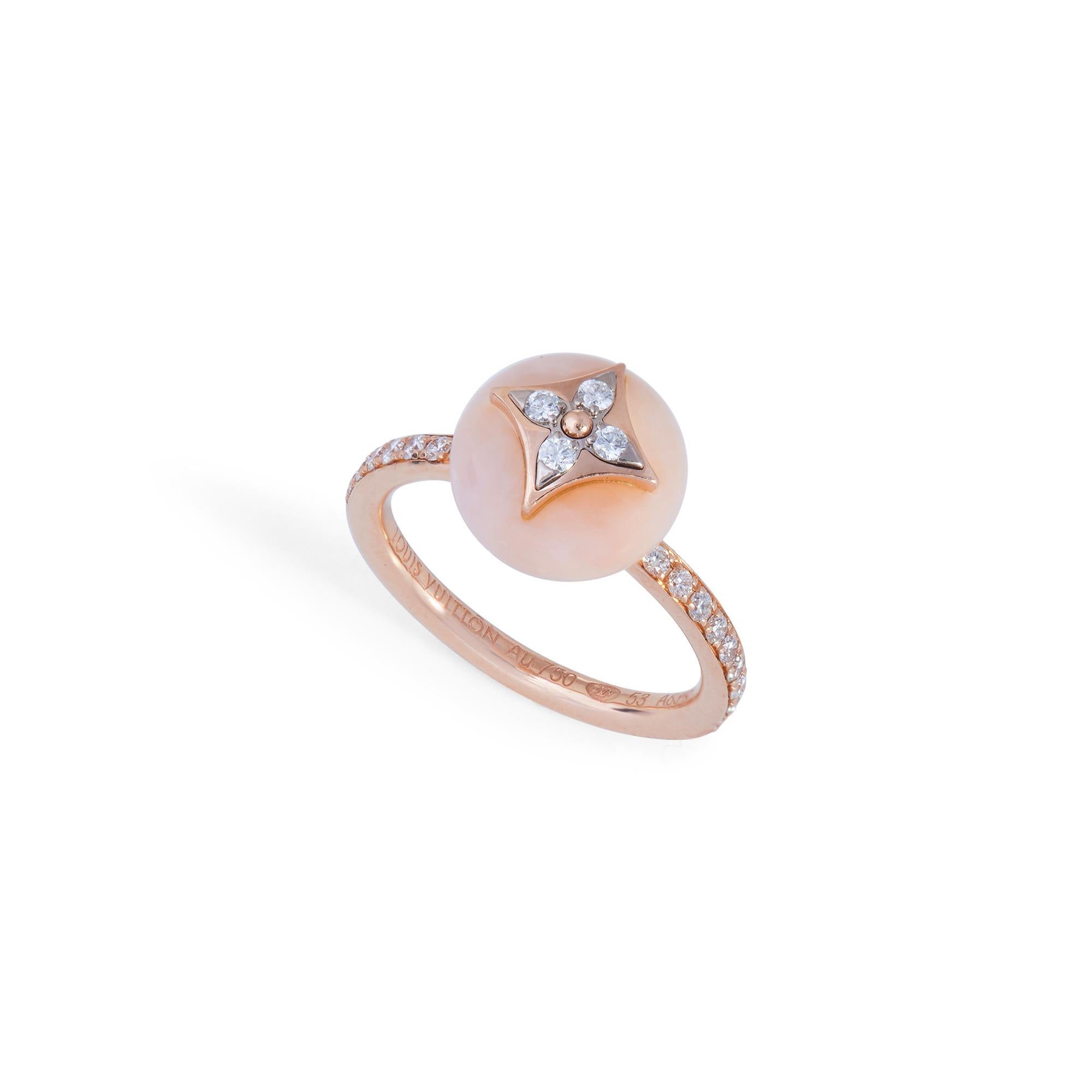 Authentic Louis Vuitton B Blossom ring crated in 18 karat rose and white gold.  The iconic Louis Vuitton monogram flower is surrounded by a rounded pink opal.  The band and monogram detail are set with approximately 0.2 carats of stunning round