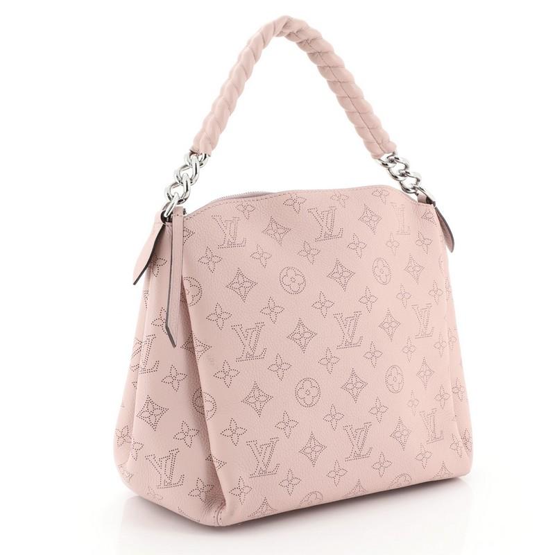 This Louis Vuitton Babylone Handbag Mahina Leather BB, crafted in pink mahina leather, features a chain top handle with leather and silver-tone hardware. Its zip closure opens to a brown microfiber interior with zip and slip pockets. Authenticity