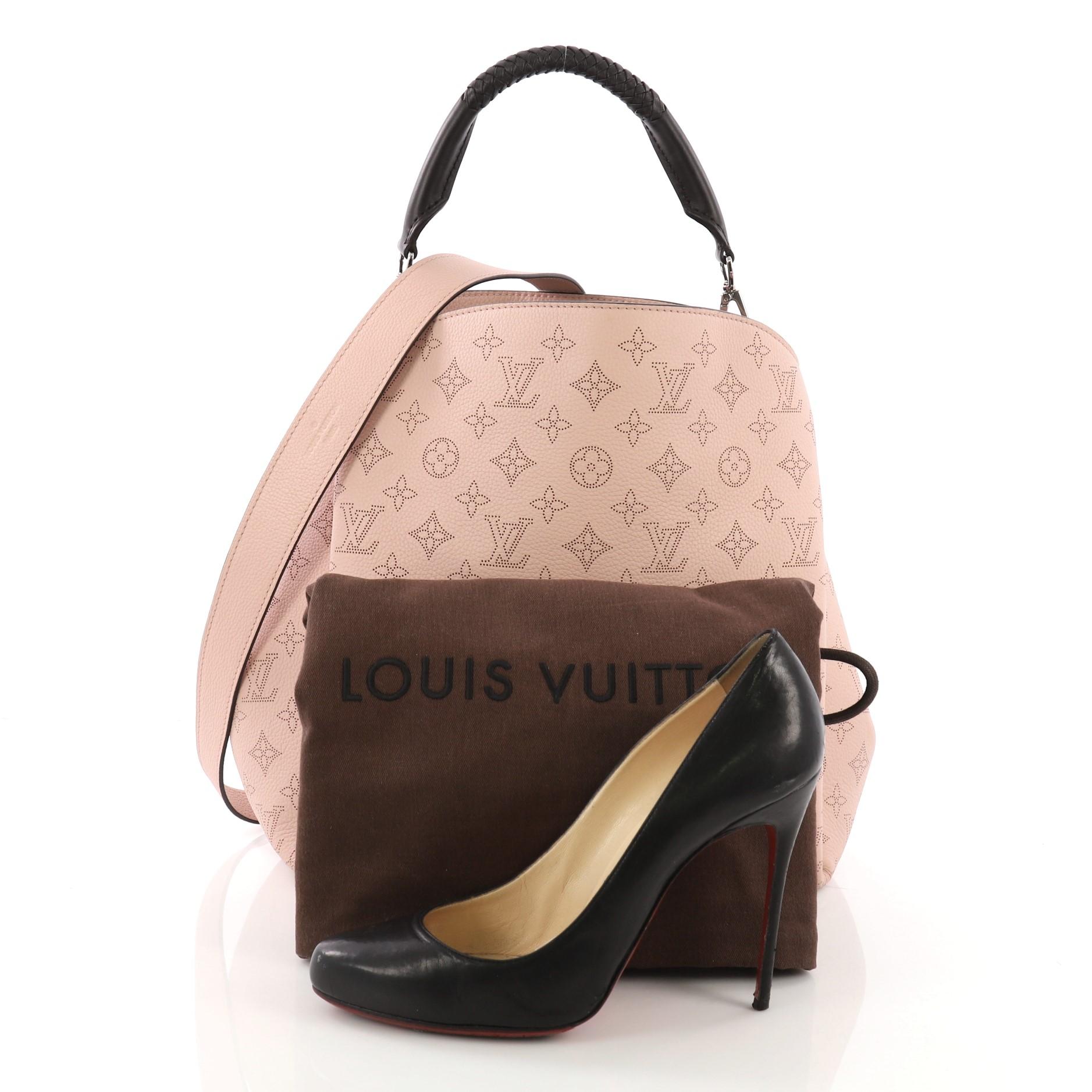 This Louis Vuitton Babylone Handbag Mahina Leather PM, crafted in pink mahina leather, features a braided leather top handle with woven trim and silver-tone hardware. Its wide open top showcases a brown microfiber interior with zip and slip pockets.