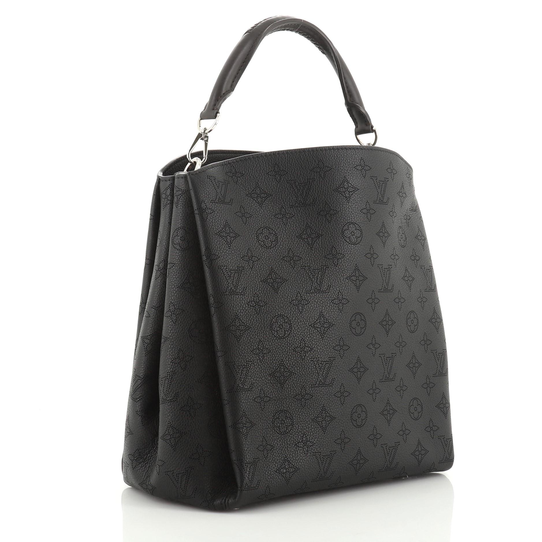 This Louis Vuitton Babylone Handbag Mahina Leather PM, crafted in black mahina leather, features a braided leather top handle and silver-tone hardware. It opens to a brown microfiber interior with zip and slip pockets. Authenticity code reads: