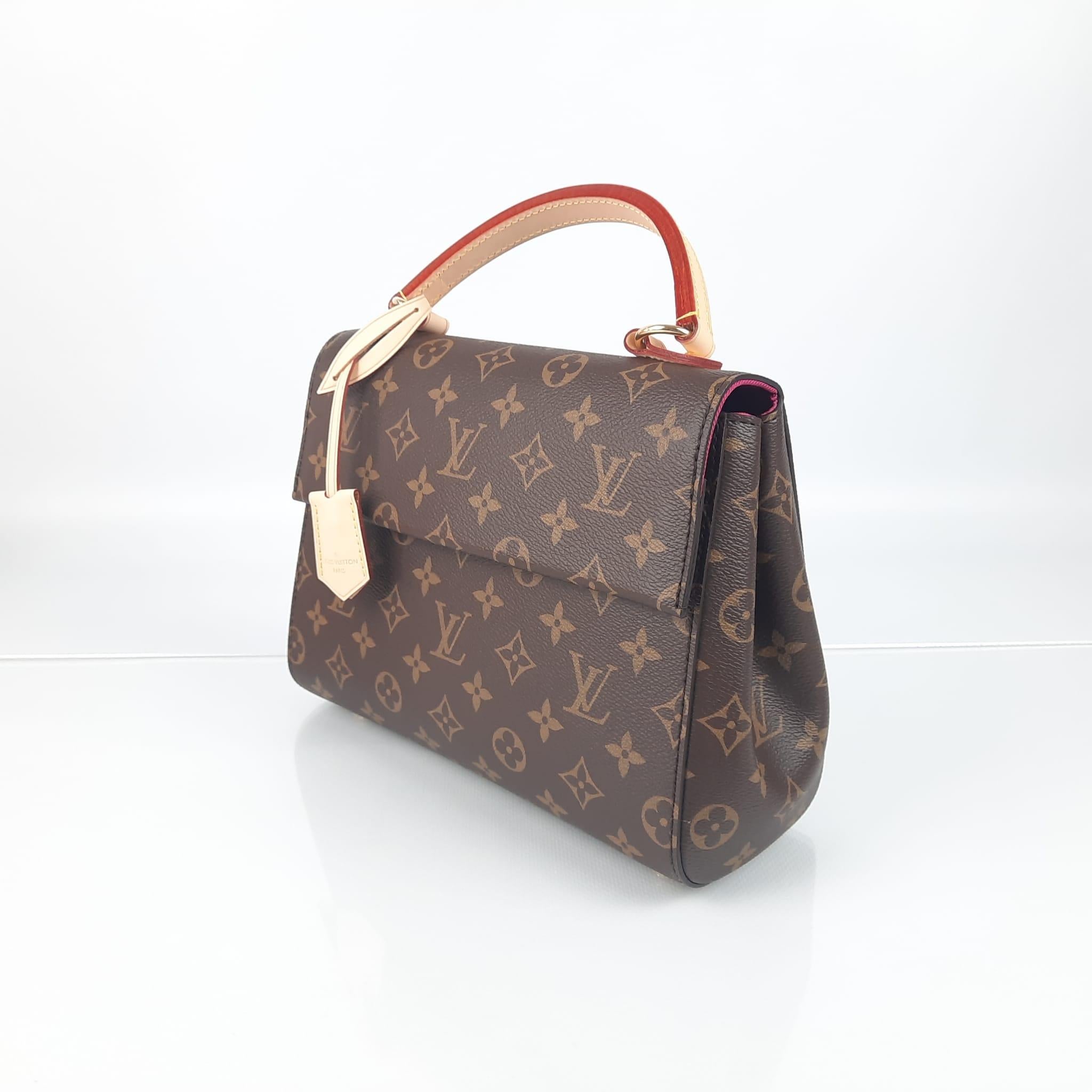 This Cluny BB bag in iconic Monogram canvas is brightened up by a colorful leather shoulder strap. Carried on the shoulder or in the hand in a feminine way, this timeless bag is designed for active life. It opens wide to reveal an organized