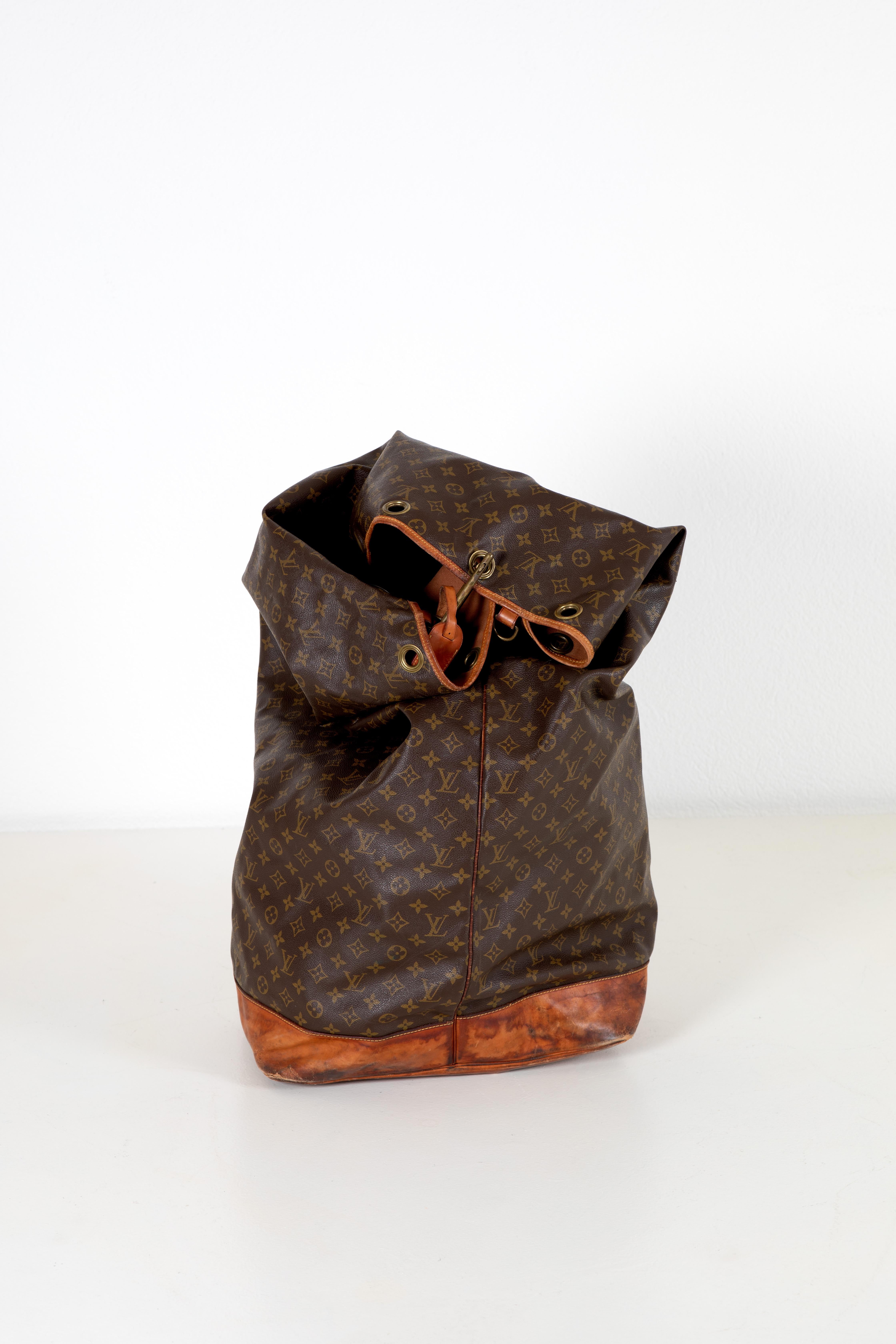 Ce sac Louis Vuitton Vintage Marin est une pièce intemporelle qui met en valeur le savoir-faire emblématique et la durabilité de Louis Vuitton. Réalisé en toile enduite et doté d'une grande serrure, ce sac illustre l'engagement de la marque en