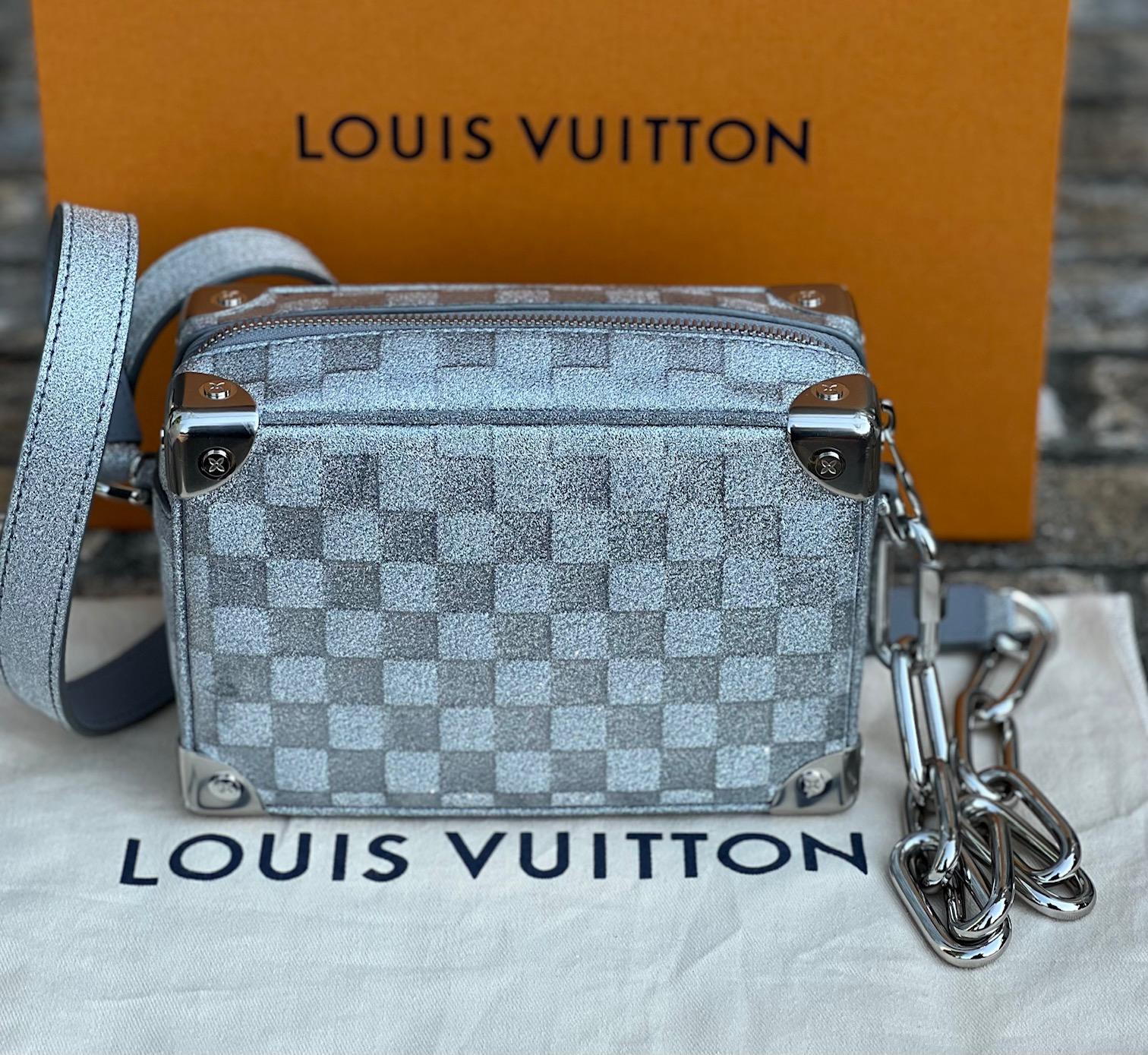 Pre-Owned  100% Authentic
LOUIS VUITTON Soft Trunk Mini Silver
Damier Glitter Crossbody Bag
RATING: A...excellent, near mint, only
slight signs of wear
MATERIAL: coated split vachetta leather
STRAP:  chain, leather and glitter
1 side is removable,