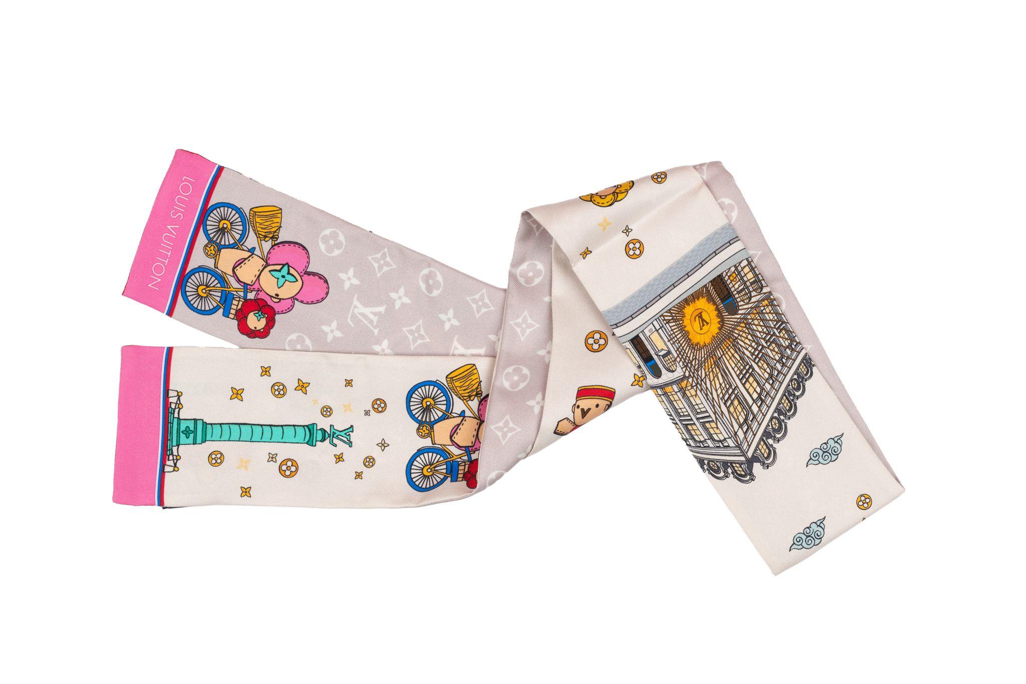 Louis Vuitton Bandeau Vivienne Paris depicts the Maison's popular mascot cycling through the streets of Paris towards the iconic Place Vendôme and Louis Vuitton store. The scarf is new and comes with the original box.