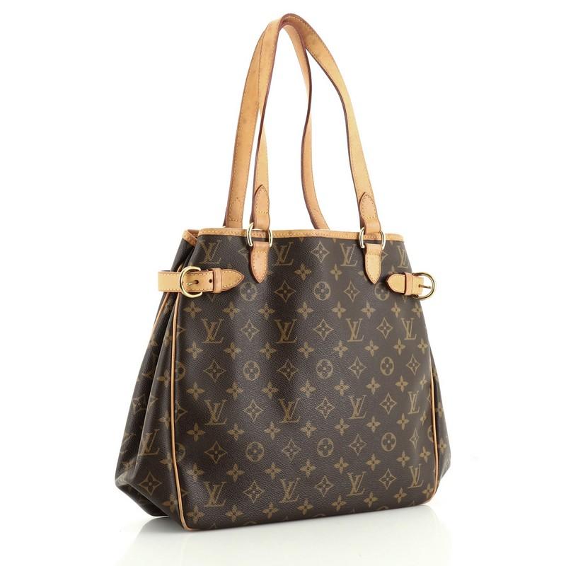 This Louis Vuitton Batignolles Handbag Monogram Canvas Vertical, crafted from brown monogram coated canvas, features cowhide leather handles and trim, side belt straps and gold-tone hardware. It opens to a brown fabric interior with side zip and