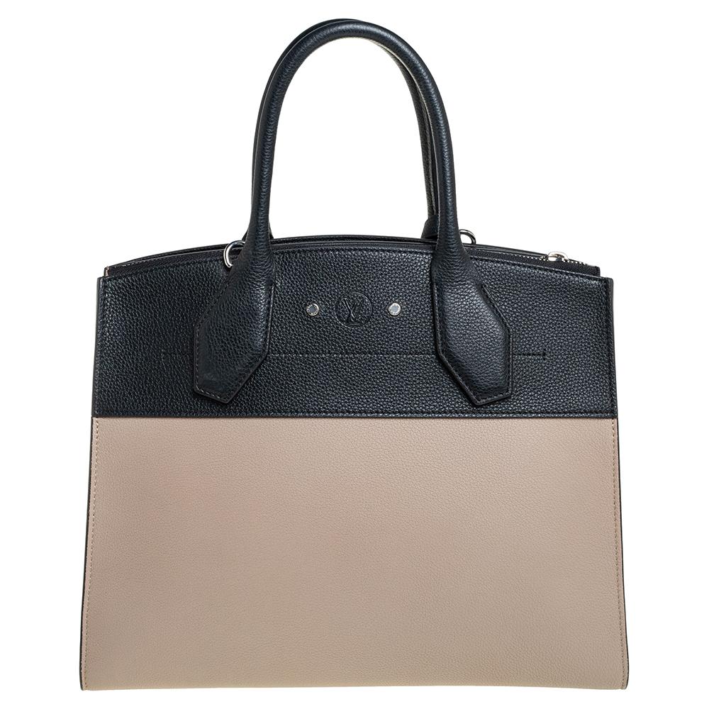 Carry this opulent and posh City Steamer MM bag by Louis Vuitton and keep all eyes on you. Crafted from beige & black leather, it features dual top rolled handles along with a detachable shoulder strap to keep you hands-free. This bag is accentuated