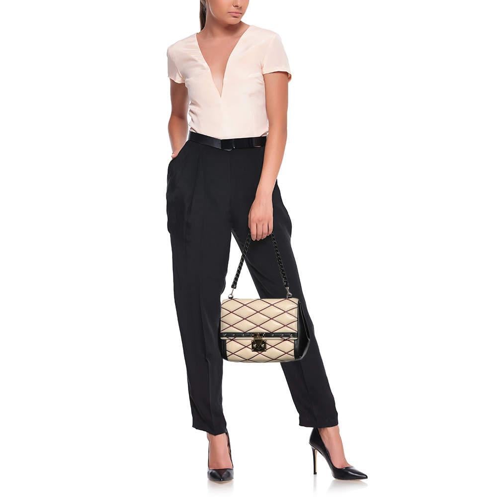 It is every woman's dream to own a Louis Vuitton handbag as appealing as this one. Coming from Louis Vuitton, this Malletage Pochette bag brings never-ending grace and poise to your style. It is made from beige-black leather with a gold-toned