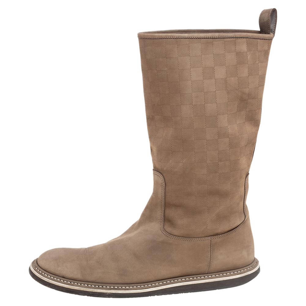 These Louis Vuitton boots embody excellence in design and craftsmanship. Crafted from suede, the mid-calf boots arrive in a beige shade. They feature round toes, Damier embossing, and rubber soles.

Includes: Original Box